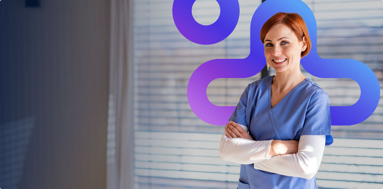 A smiling older woman wearing glasses talking with a healthcare professional across a clinic counter
